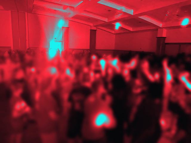School dance with glow sticks, shown as a red and cyan duotone