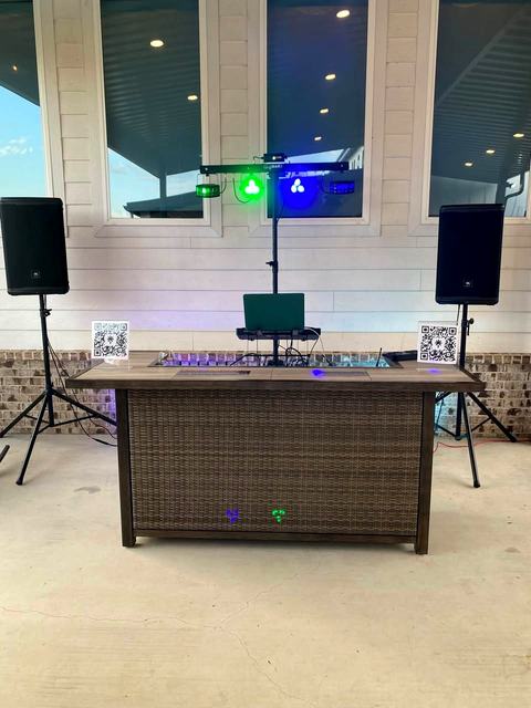 Outdoor patio DJ rig with two JBL speakers and a GigBAR light bar